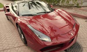 Red Ferrari under palm trees