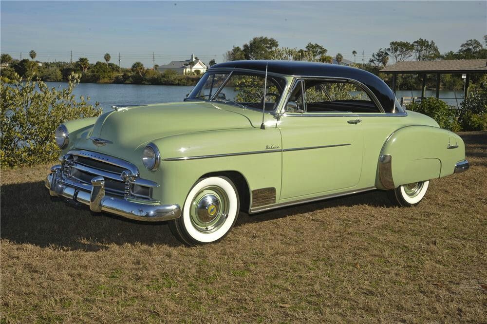 Green colored 1950 Chevrolet Bel Air parked in the grass 