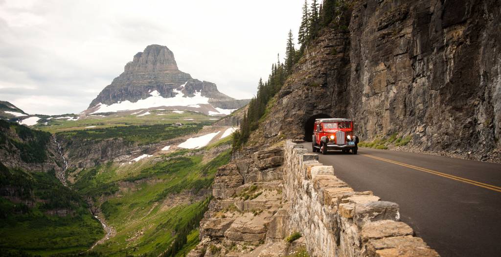Classic red truck traveling along the Going to the Sun road