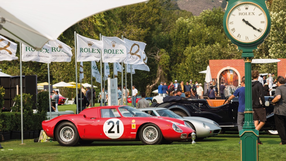 Classic Ferraris on the grass next to a Rolex booth at The Quail, a premier motoring event