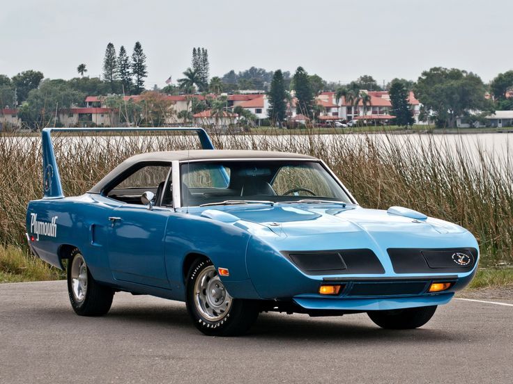 Blue Plymouth Superbird with rear wing parked in front of a lake