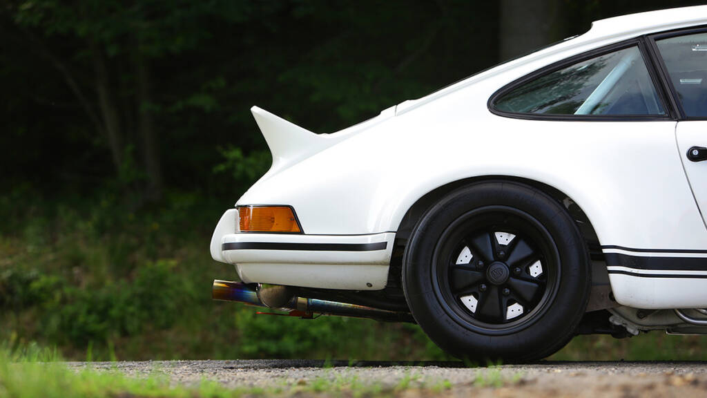 A tail end of a white Porsche 911