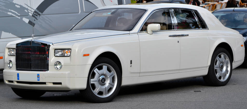 Pearl colored Rolls-Royce Phantom VII driving in a busy city