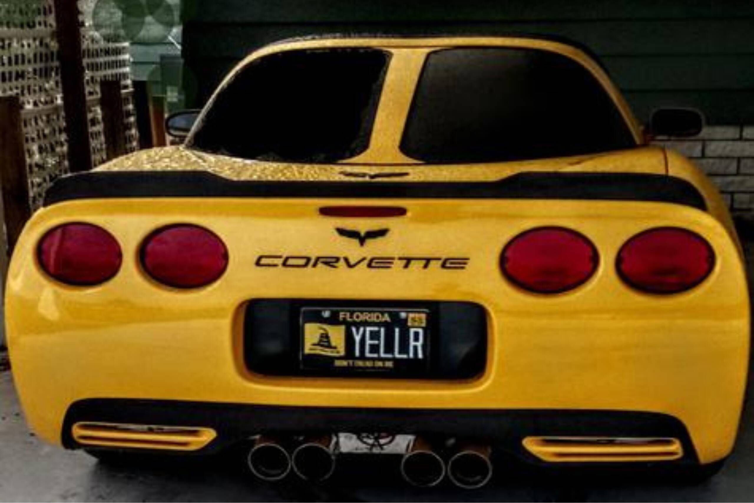 Yellow chevrolet corvette with custom license plate