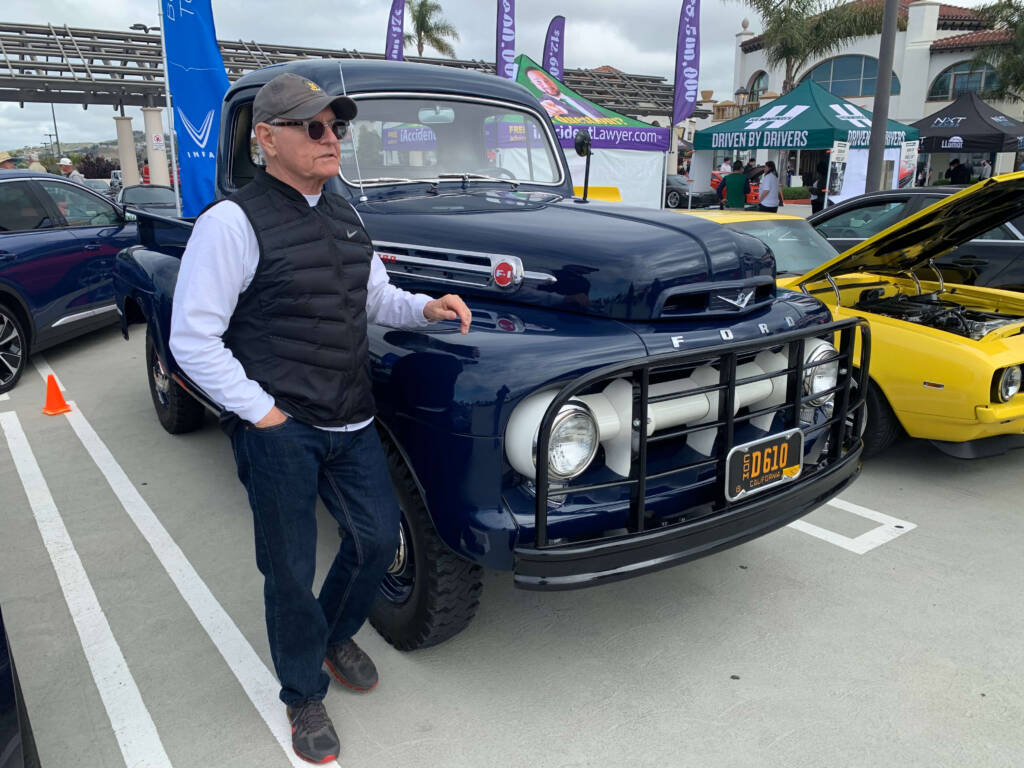 Classic Ford truck parked next to classic car owner