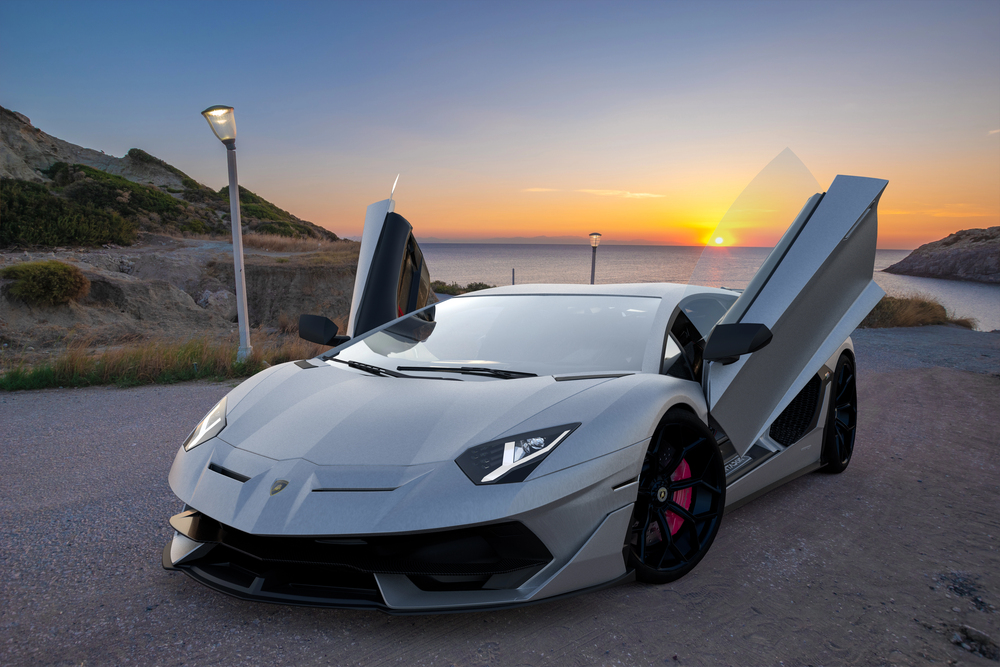 Grey lamborghini with butterfly doors open and sunset in background
