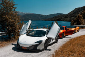 White Mclaren with doors open near the coast