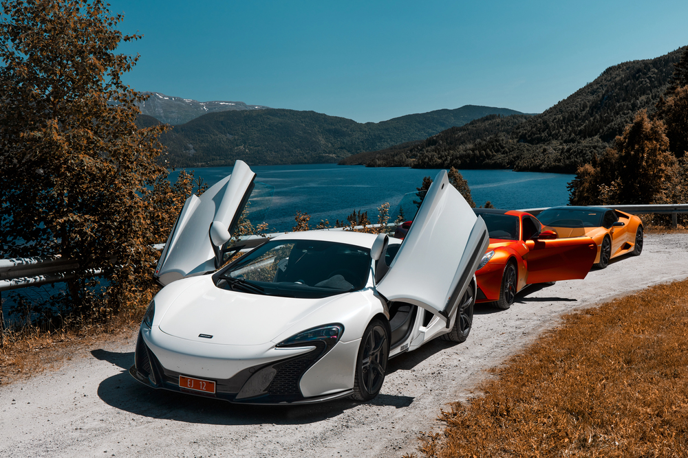 White Mclaren with doors open near the coast