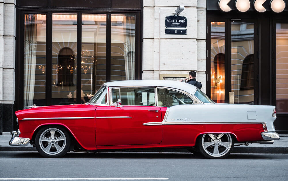 red classic car parked outside of a city building