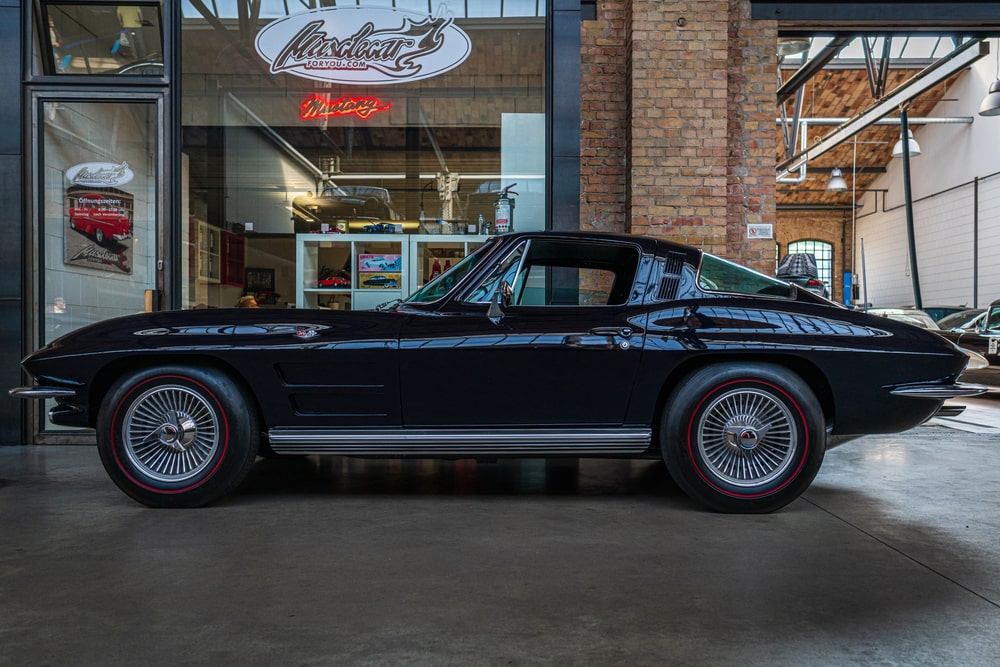 Black classic Corvette parked in a car garage