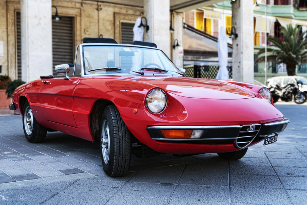 Classic Alfa Romeo Spider parked in front of hotel
