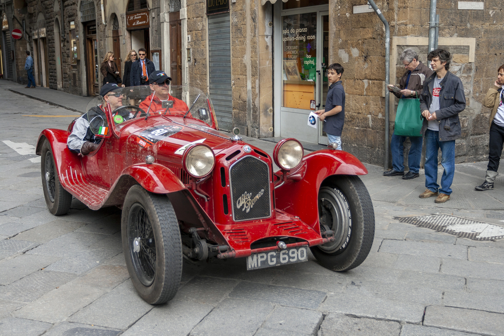 Red Alfa Romeo 8C 2300 from the 1930s driving on the roads in Europe