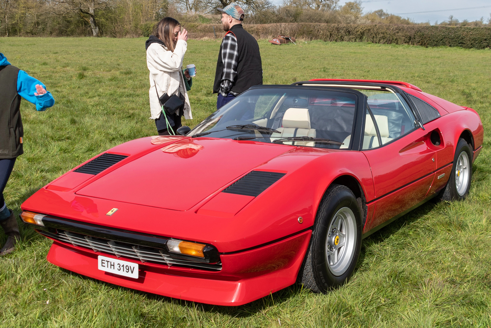 Red 1980 Ferrari 308 GTS with the rooftop down in the grass