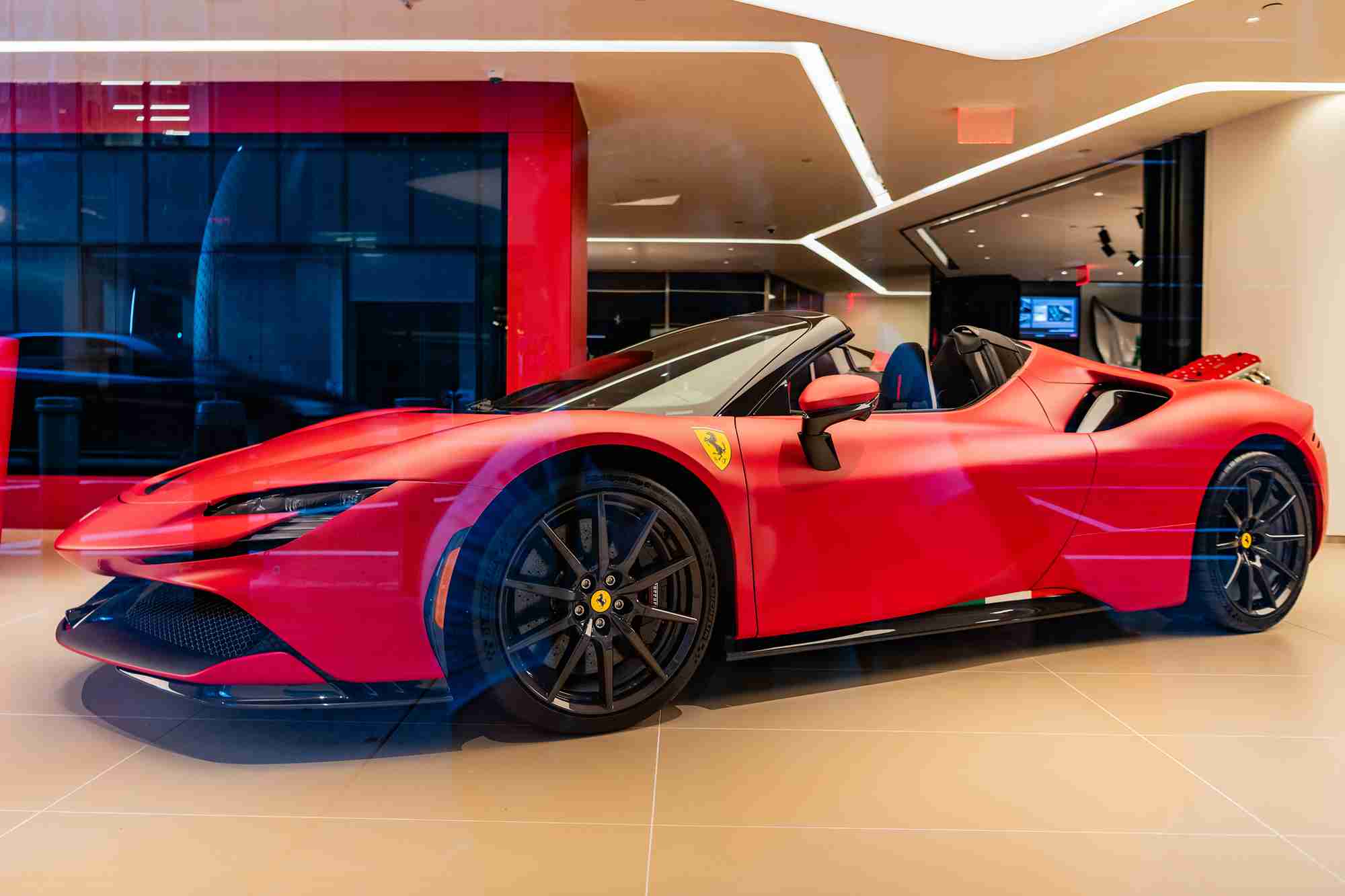Cherry red Corvette parked outside of a Chevrolet dealership