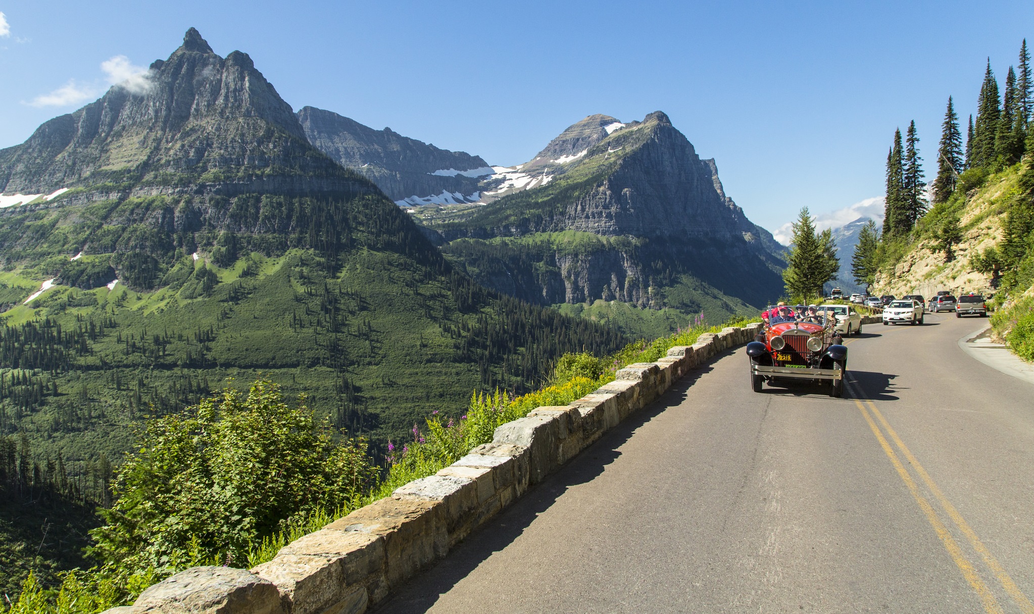 Classic red truck traveling along the Going to the Sun road